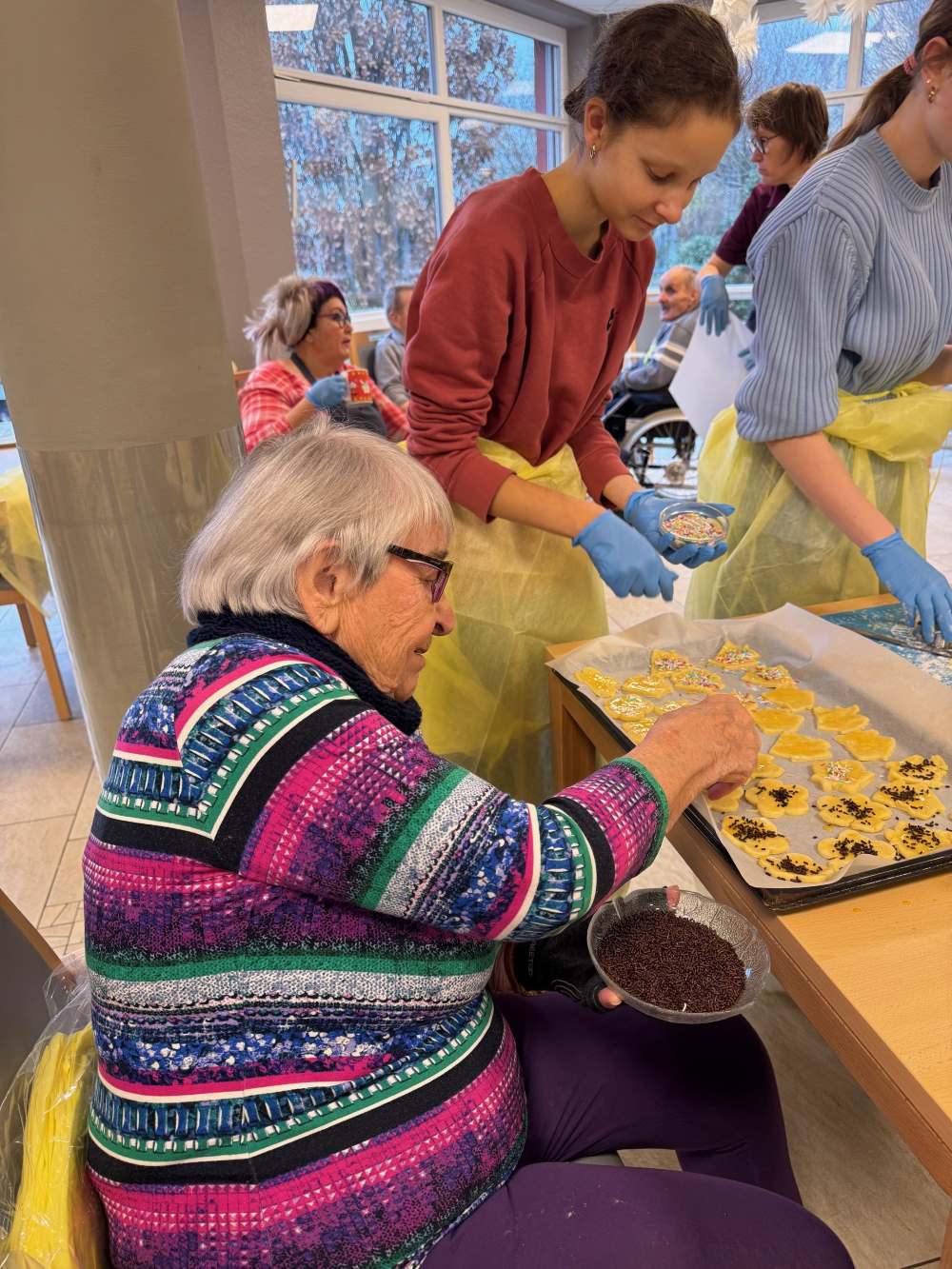 Bewohner und Schüler beim gemeinsamen Backen in der Weihnachtsbäckerei des Haus Antonius
