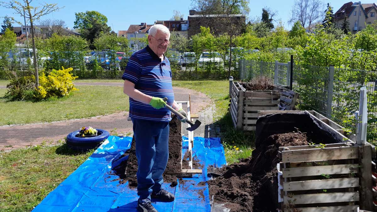 Residents of the Bölschestraße retirement home with a shovel in front of the new raised flowerbed