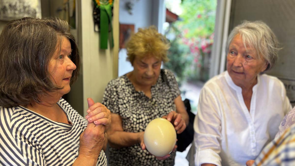 Bewohner*innen kaufen im Hofladen der Straußenfarm ein