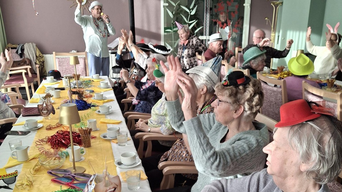 Faschingsfeier in der ProCurand Seniorenresidenz Cottbus: Verkleidete Bewohner*innen sitzen gemeinsam am Tisch, lachen, feiern und genießen die ausgelassene Stimmung.