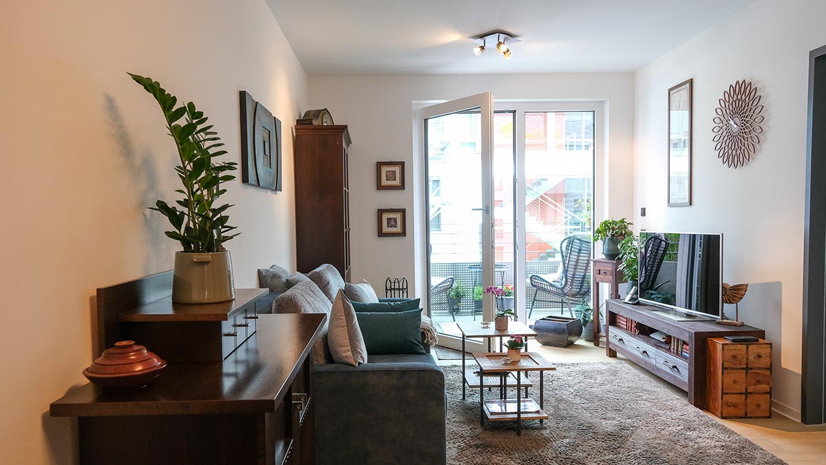 Eingerichtetes Wohnzimmer eines Apartments zeigt Raumkonzept und pflegeleichte Bodenbeläge
