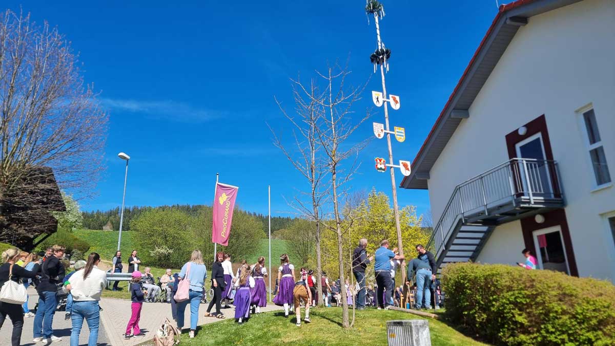 The Social Care team at Pflegestift St-Ulrich is putting up the Maypole in front of the facility.
