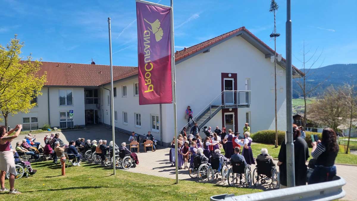 Senior citizens watch the performance of the Lohberg folk costume group at the May festival of the St. Ulrich care home.
