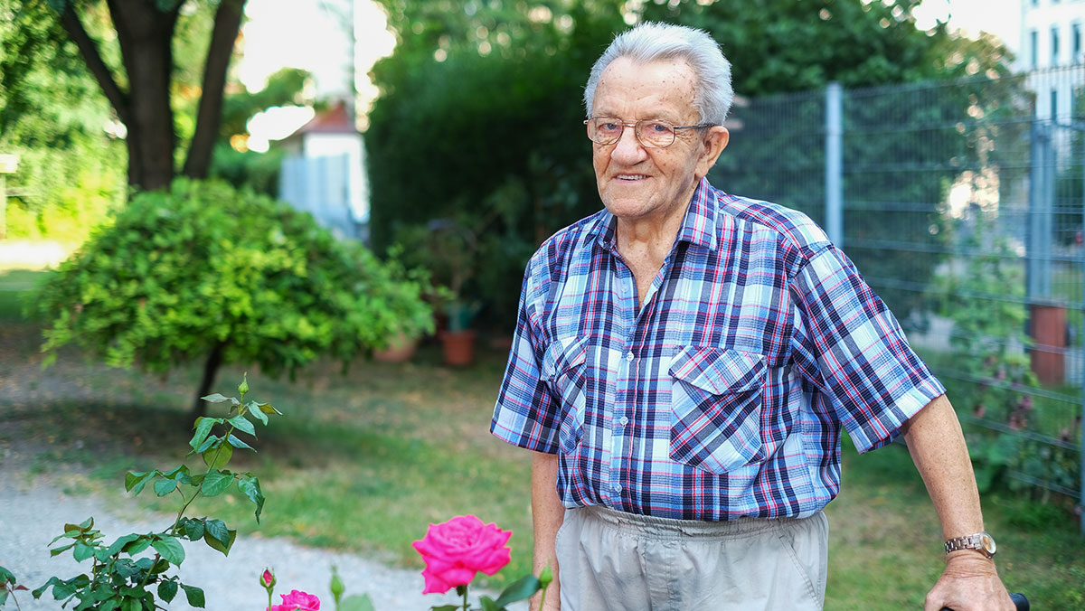Ein Senior befindet sich draußen im Garten des Service-Wohnens der Seniorenresidenz Am Krökentor