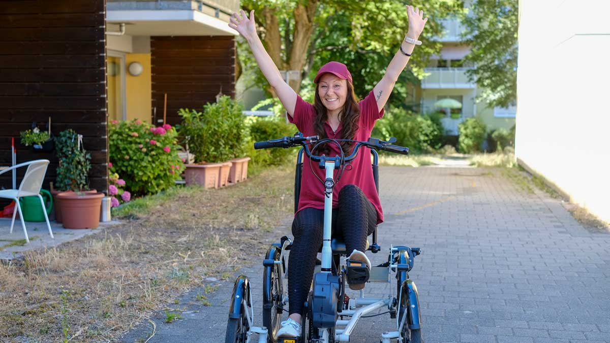 Pflegehelferin fährt ein Vierrad auf dem Außengelände der Ambulanten Pflege Potsdam
