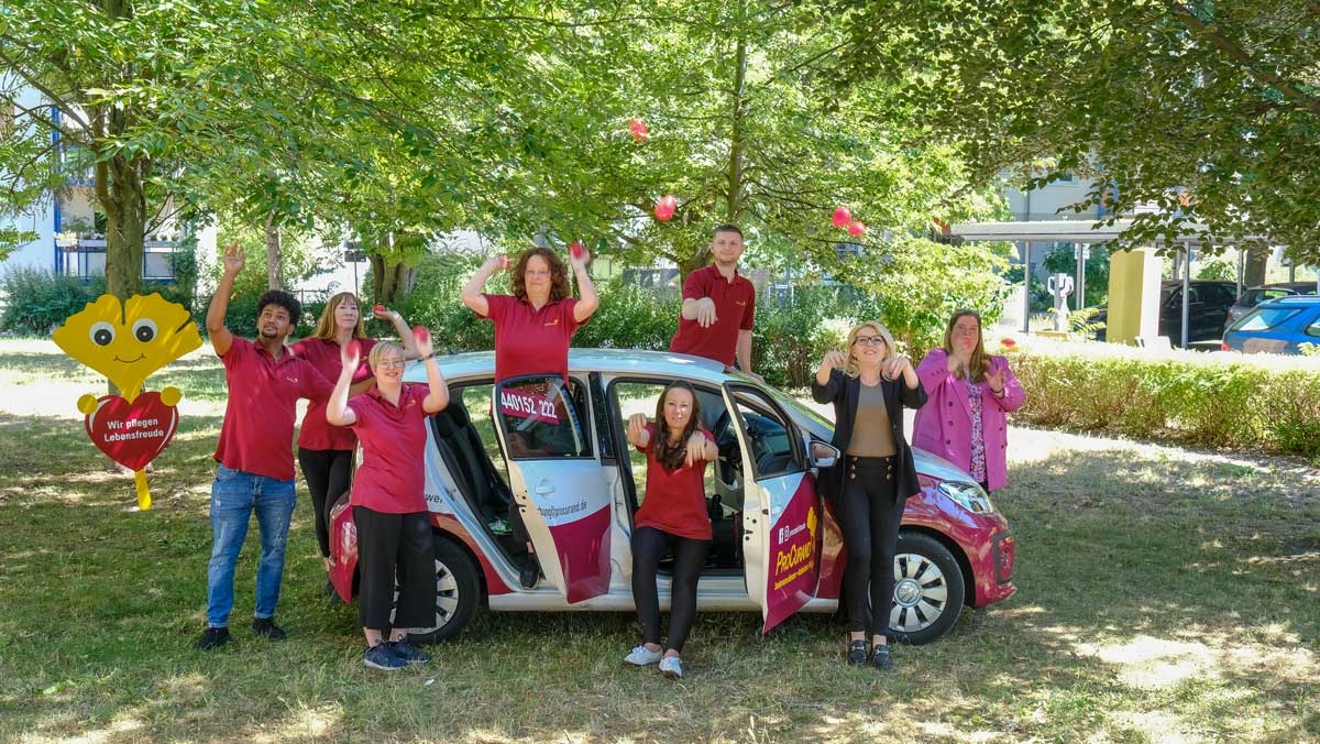 Team Ambulante Pflege Potsdam neben dem ProCurand-Auto und mit ProCurand-Herzen
