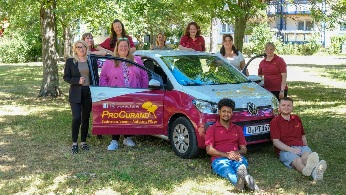 Team Ambulante Pflege Potsdam neben dem ProCurand-Auto