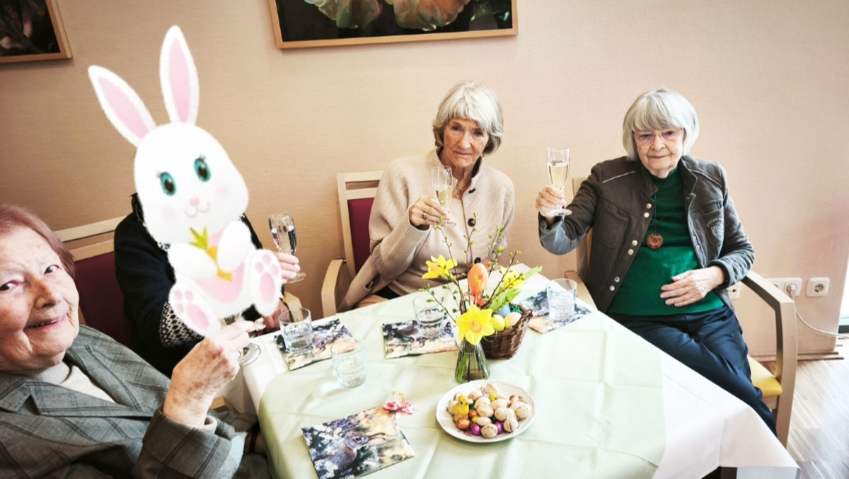 Senior*innen mit Sektgläsern beim gemeinsamen Osterfest in der Seniorenresidenz Park Sanssouci