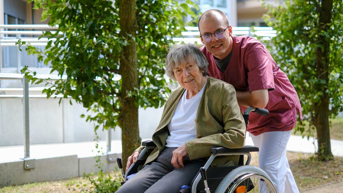 Seniorin mit Wohnbereichsleitung der Stationären Pflege in der Seniorenresidenz Park Sanssouci beim Parkspaziergang im Park der Residenz