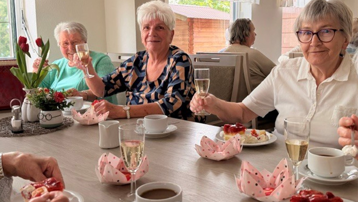 Seniorinnen sitzen gemeinsam bei angenehmer Stimmung