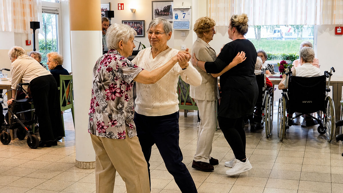 Senior*innen tanzen gemeinsam im Saal der Seniorenresidenz Senftenberg
