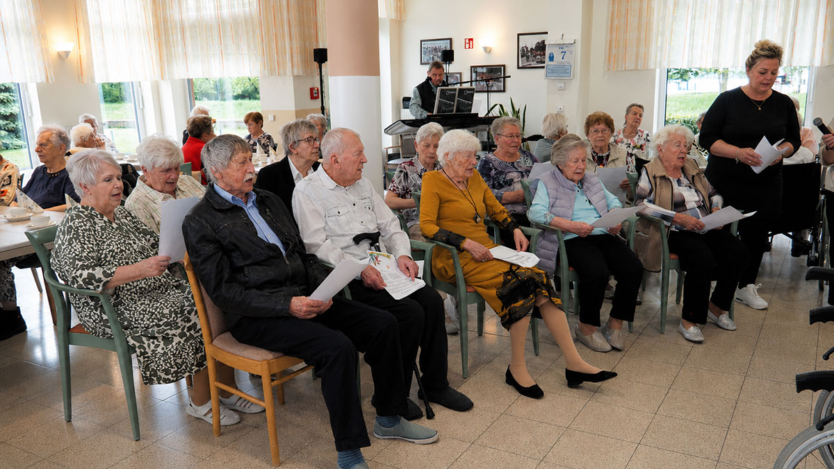 Senior*innen der Seniorenresidenz Senftenberg schauen dem Chor bei seinem Auftritt zu