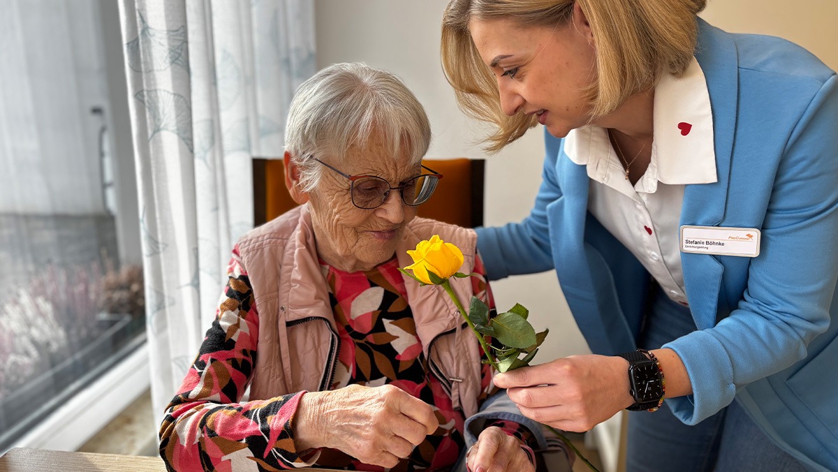 Nursing manager of the Bölschestraße senior citizens' residence presents a senior citizen with a rose on Women's Day
